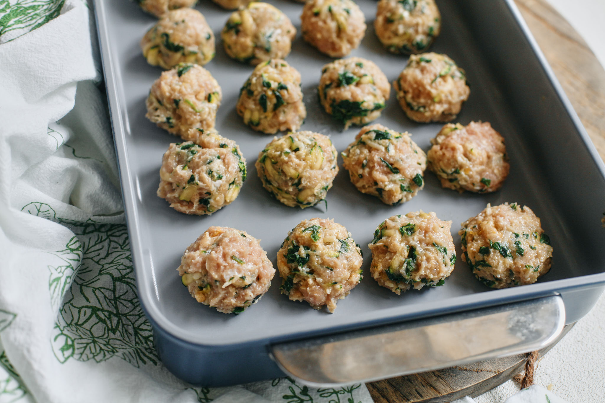 raw chicken meatballs that are formed and ready to bake