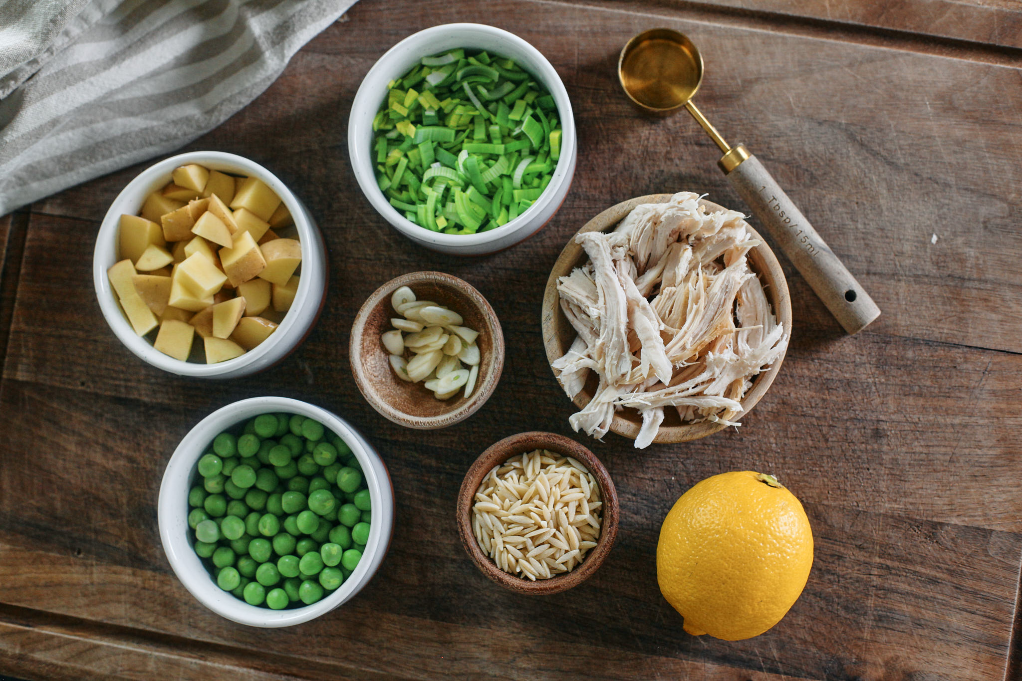 prep for the soup: chopped leek, potatoes, sliced garlic, peas, shredded chicken and lemon