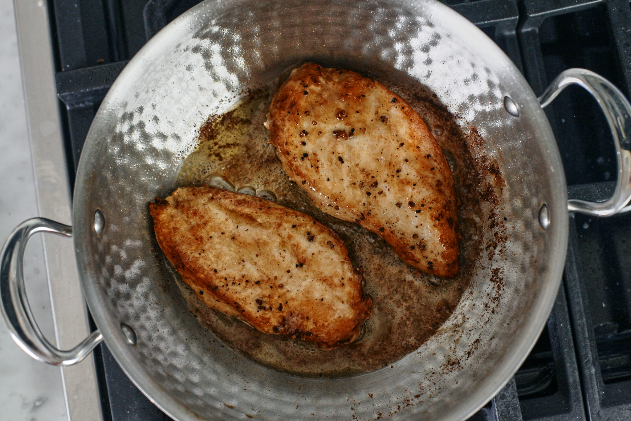 searing the chicken breasts in a skillet