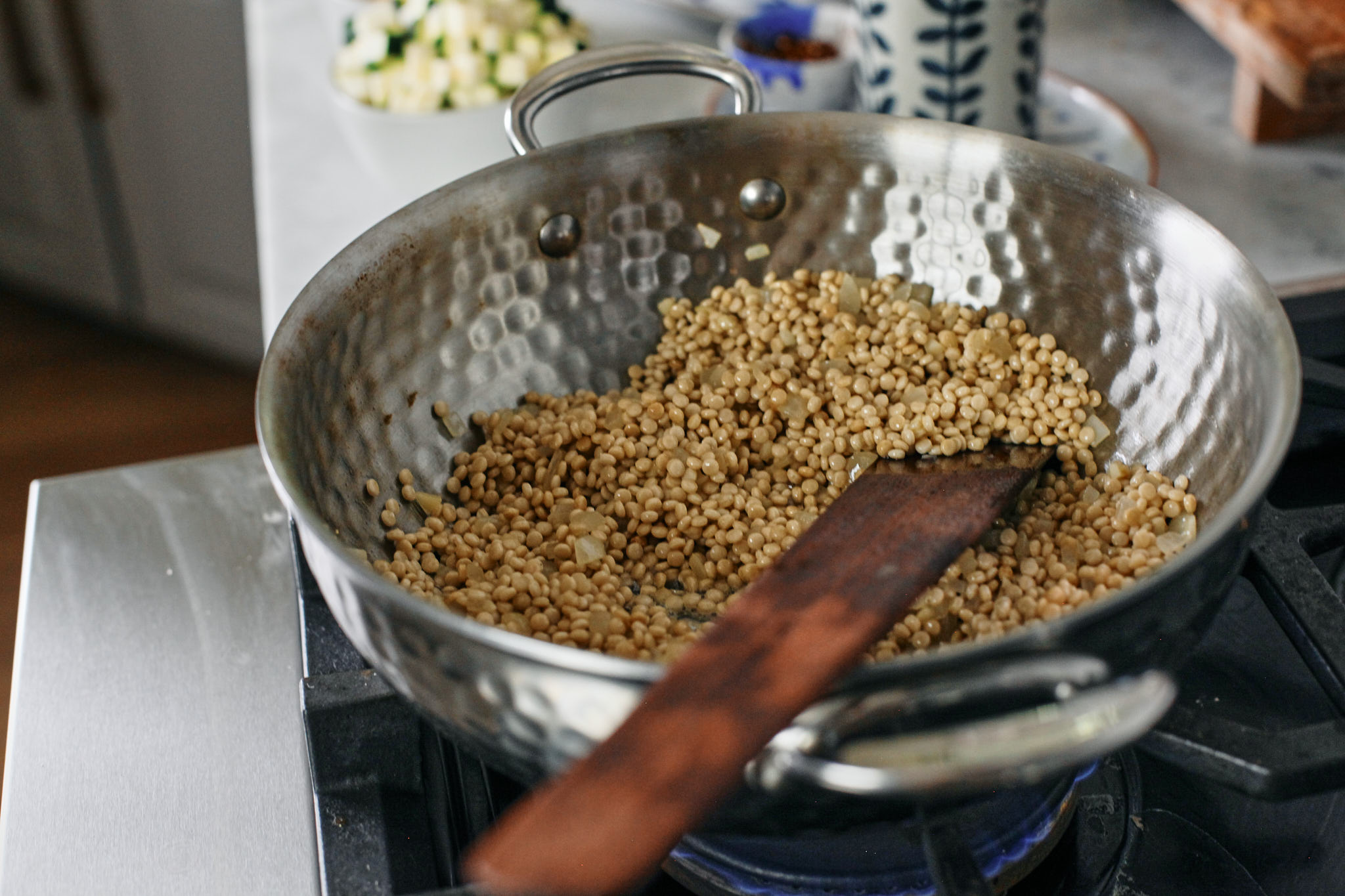 toasting the pearl couscous with butter, olive oil, onions and garlic