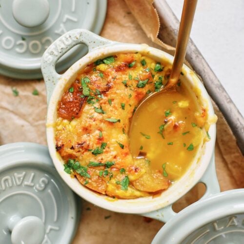 crocks of golden garlic soup after being broiled
