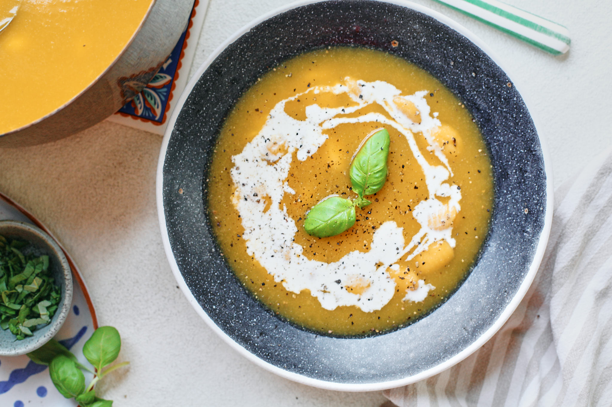 hidden vegetable gnocchi soup with cream and basil on top