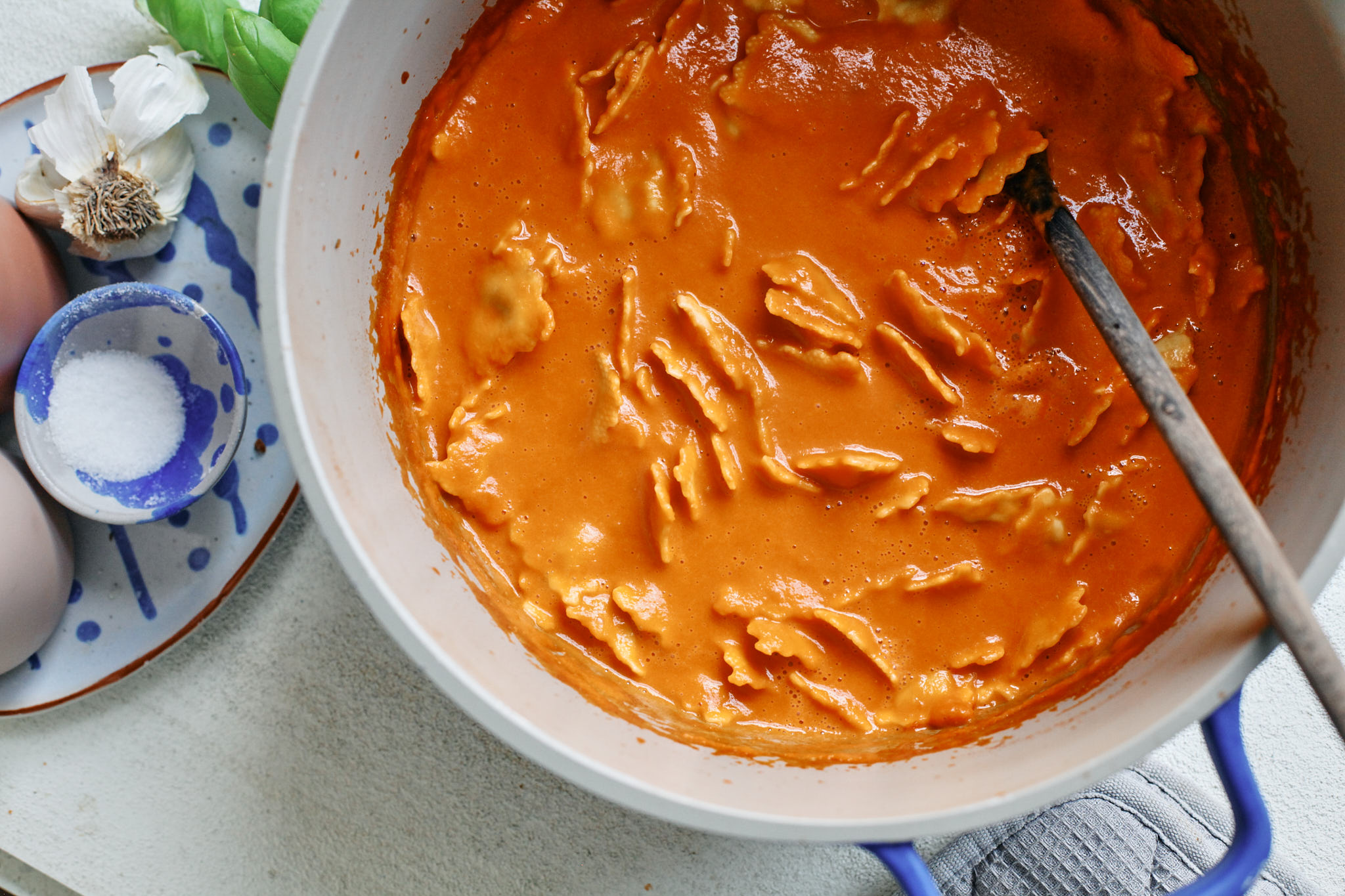 Creamy Tomato Ravioli Soup in a white bowl with basil garnish and a drizzle of cream, perfect cozy dinner recipe