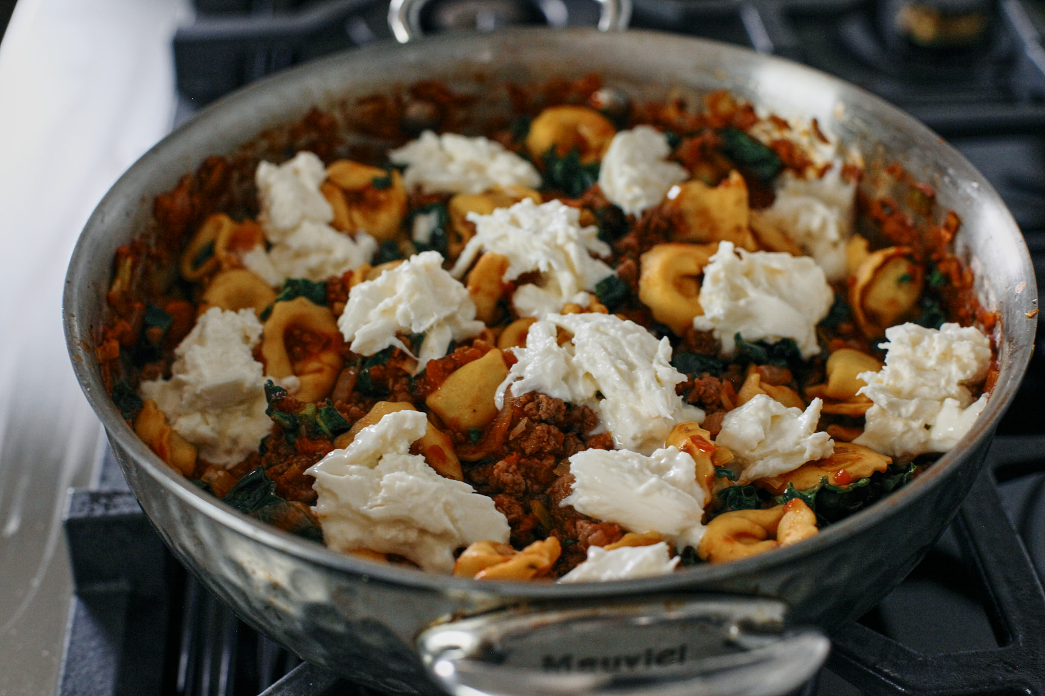 tuscan tortellini bake topped with creamy burrata about to go into the oven