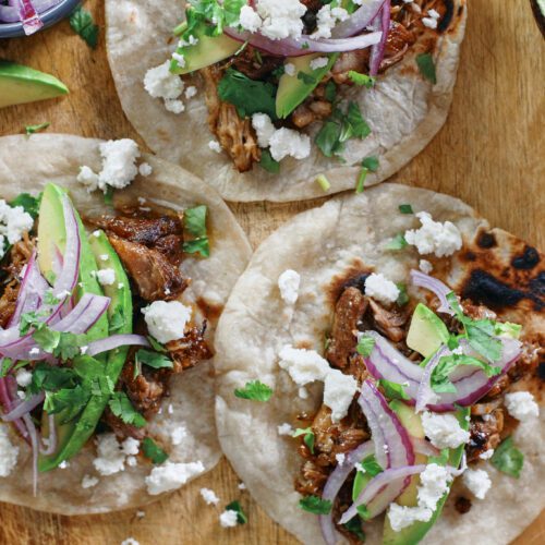 citrus braised pulled pork tacos with avocado, pickled onions, cilantro, queso fresco