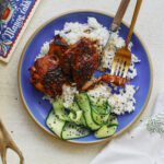 sticky sesame dijon chicken over rice with a cucumber salad