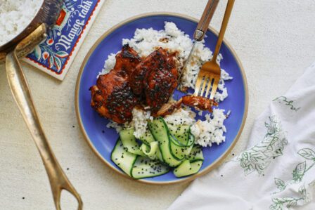 sticky sesame dijon chicken over rice with a cucumber salad