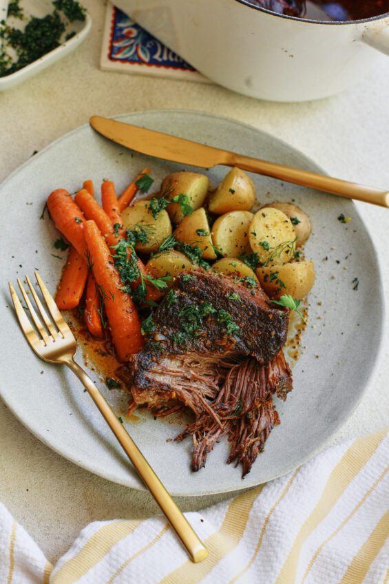 ale braised pot roast plated with baby potatoes and carrots