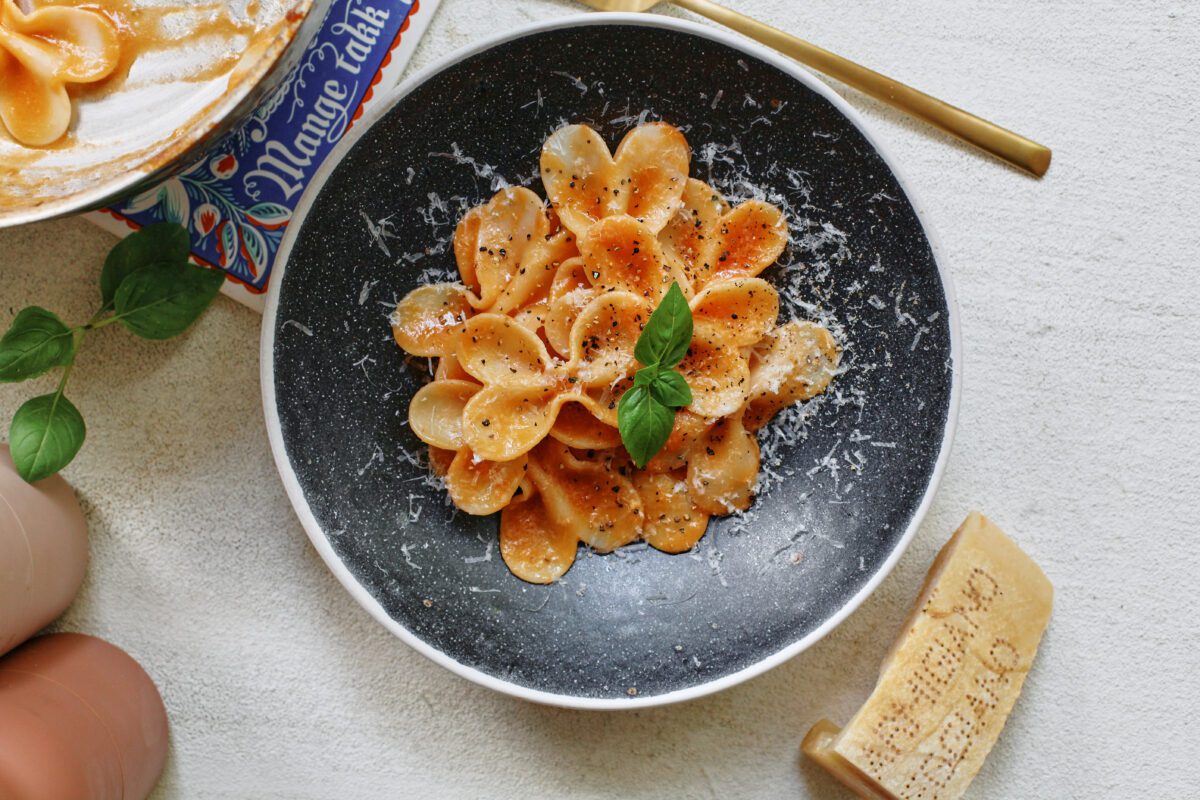 single serve tomato pasta garnished with parmesan and basil