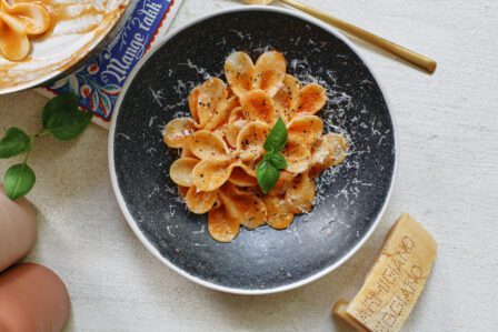single serve tomato pasta garnished with parmesan and basil