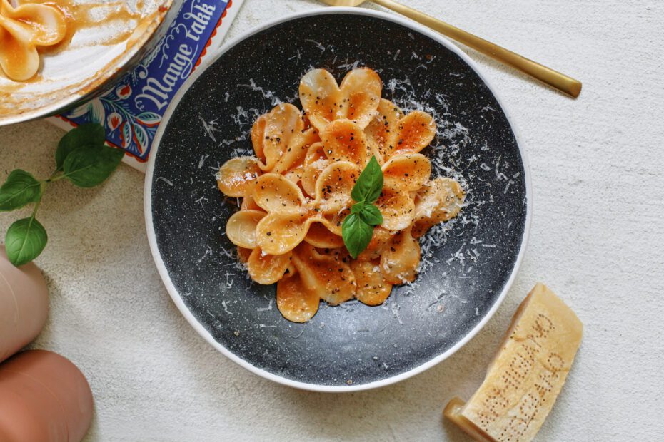 single serve tomato pasta garnished with parmesan and basil