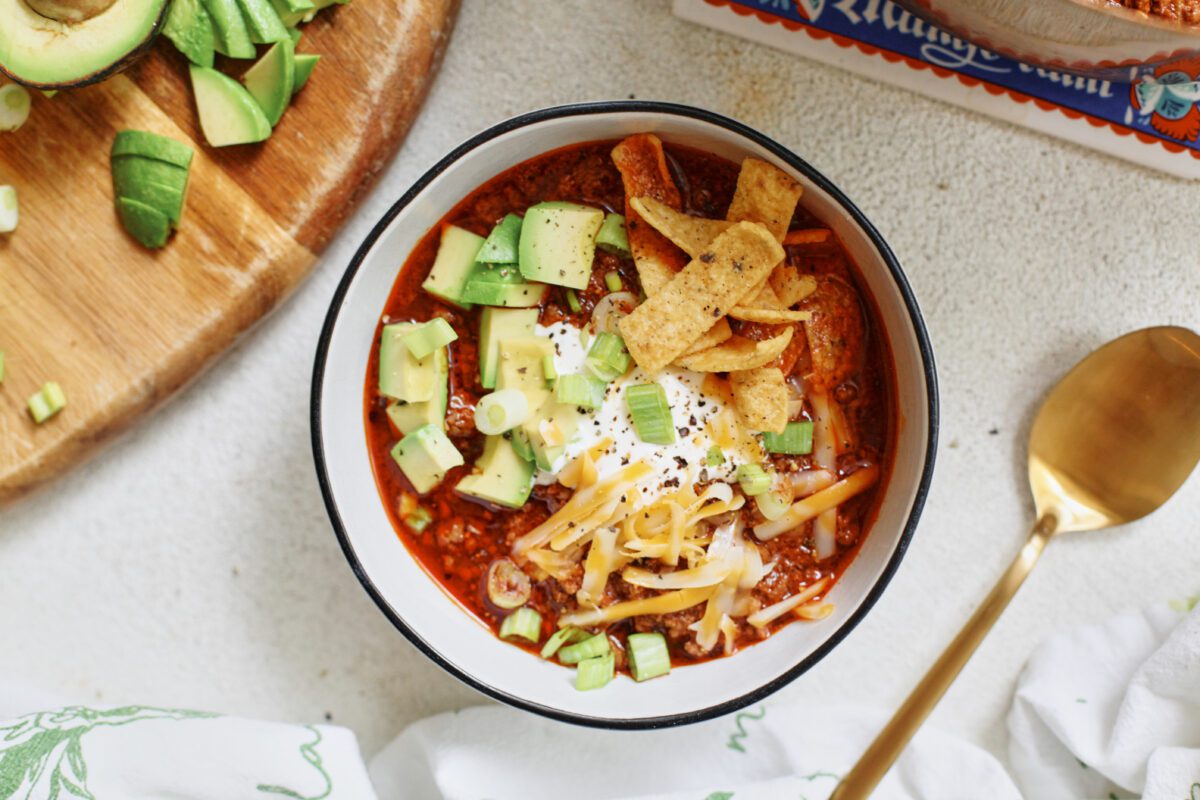 texas style chili topped with sour cream, avocado, green onions, shredded cheese, and fritos