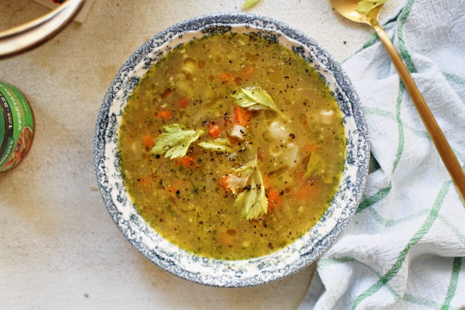 pesto minestrone soup in a white and blue floral-patterned bowl