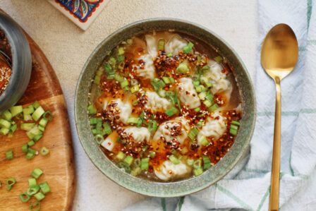 wonton soup topped with green onions and chili oil