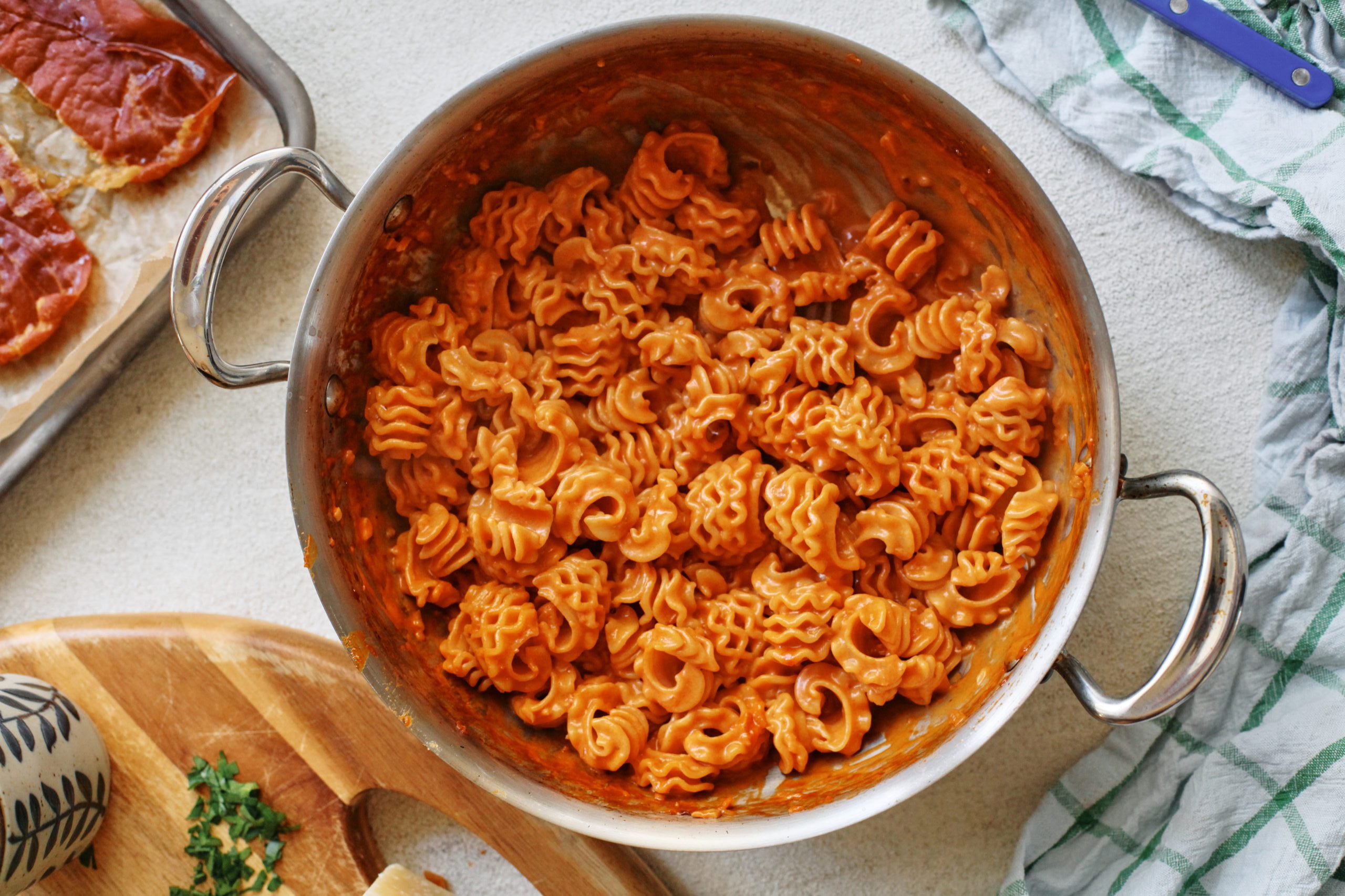 a large hammered steel saute pan filled with vodka sauce covered radiatore