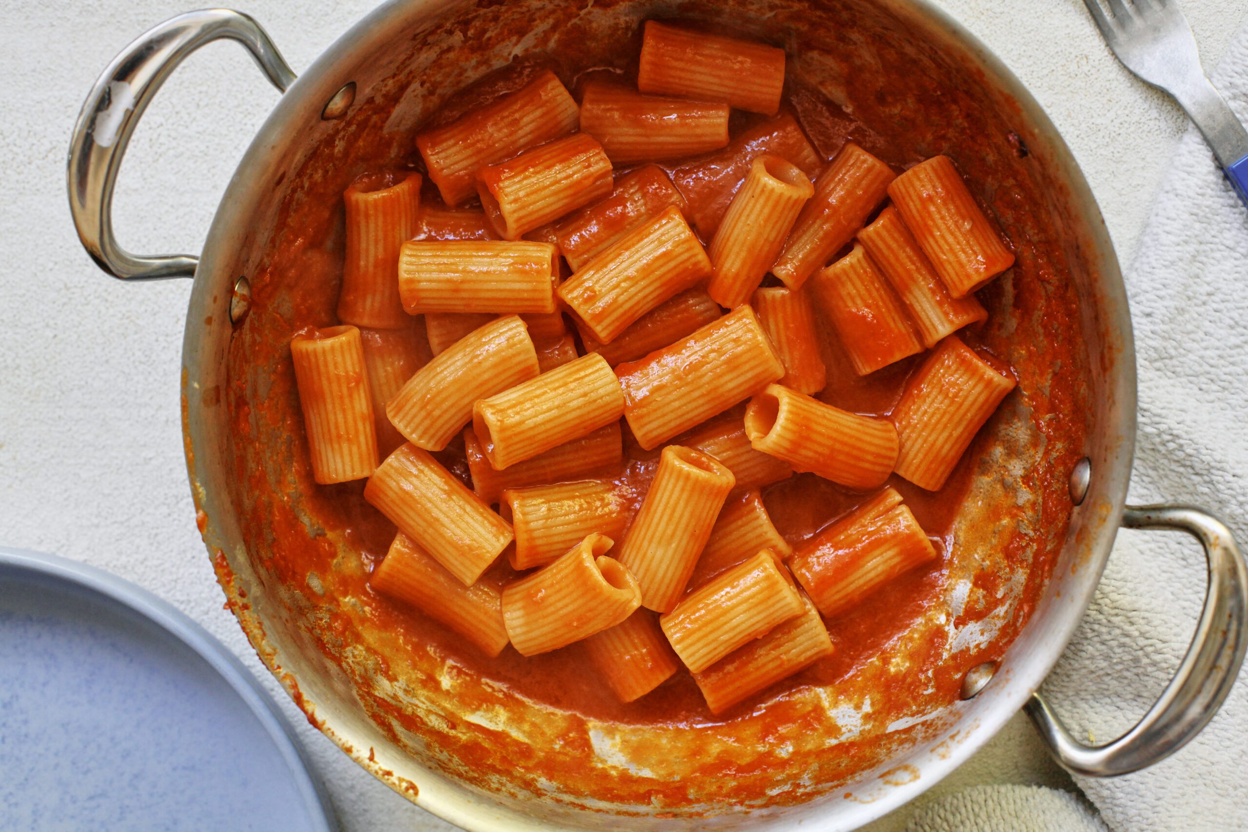 Tomato ginger butter rigatoni in a steel saute pan