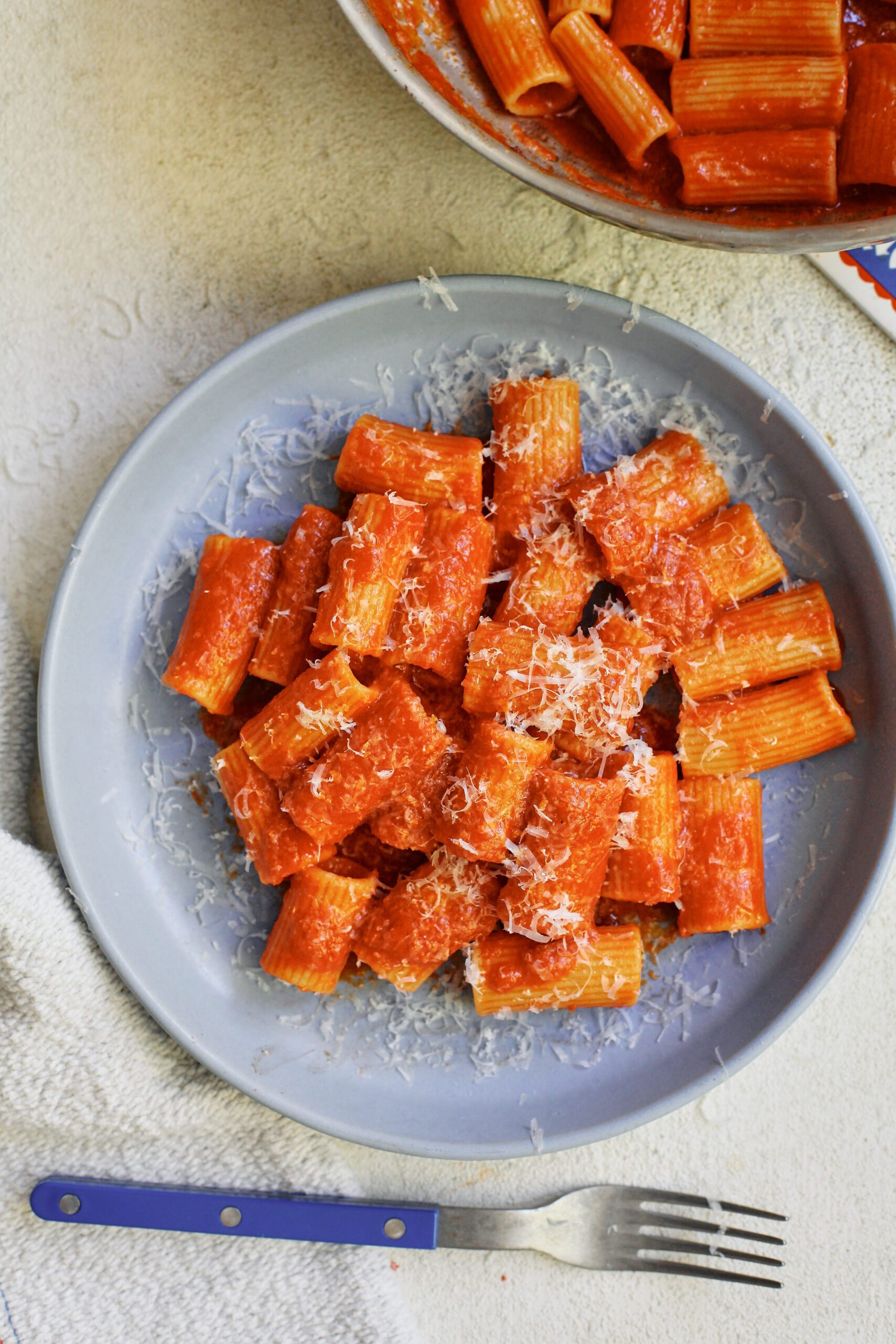 Tomato ginger butter rigatoni on a light blue plate