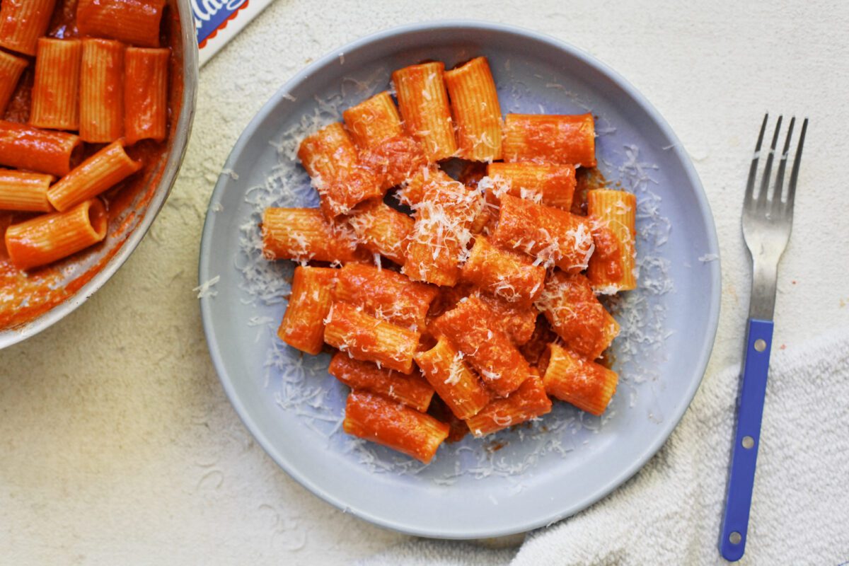 Tomato ginger butter rigatoni on a light blue plate
