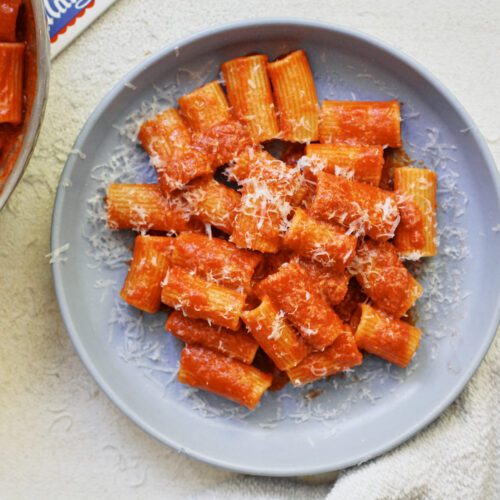 Tomato ginger butter rigatoni on a light blue plate