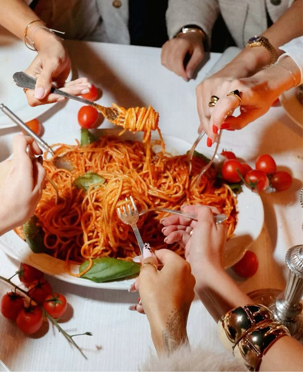 hands together eating spaghetti