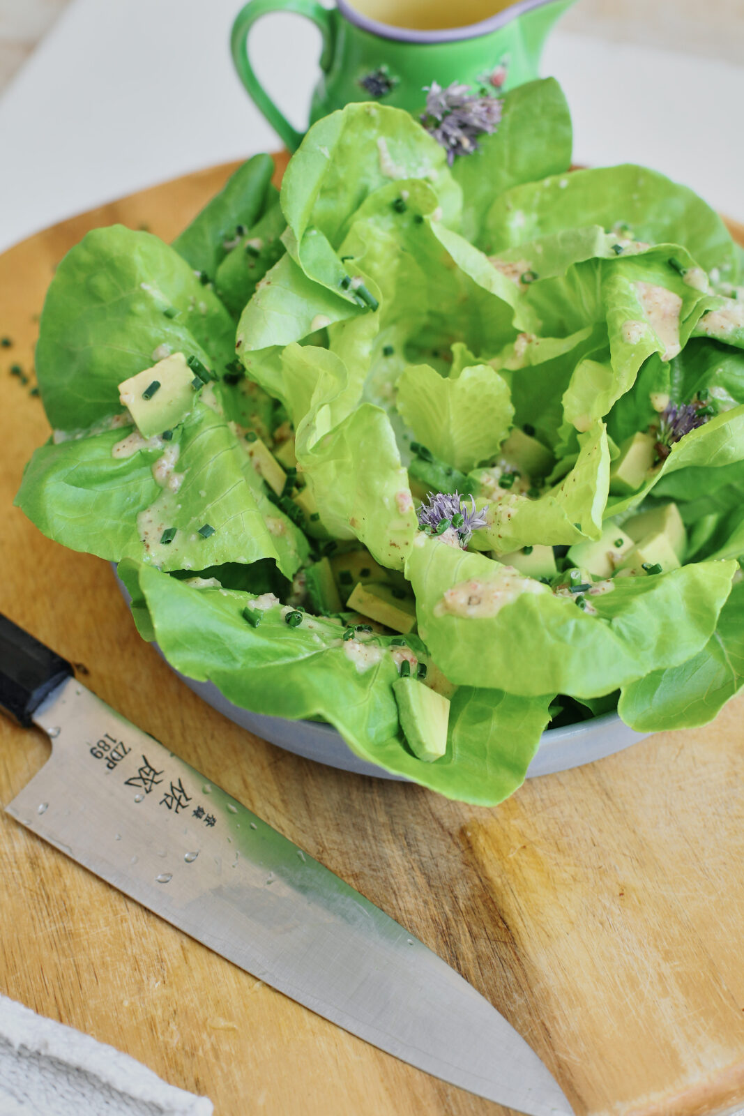 butter lettuce toped with chives, dressing, and cubed avocado