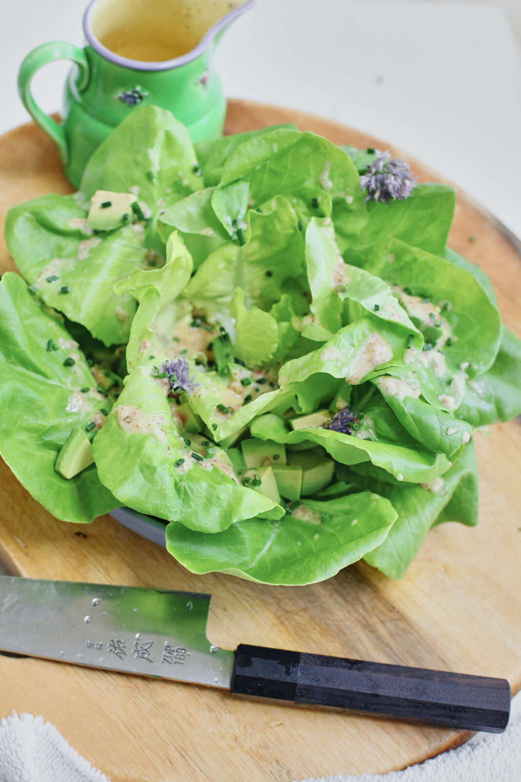 butter lettuce toped with chives, dressing, and cubed avocado