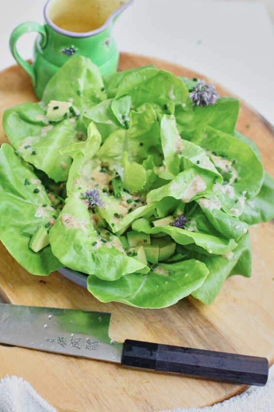 butter lettuce toped with chives, dressing, and cubed avocado