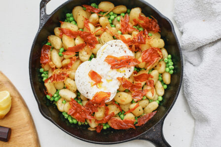 Crispy Gnocchi with Burrata, Peas & Prosciutto in a cast iron skillet