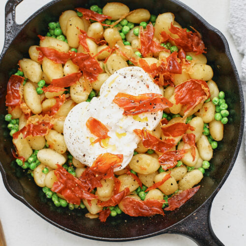 Crispy Gnocchi with Burrata, Peas & Prosciutto in a cast iron skillet
