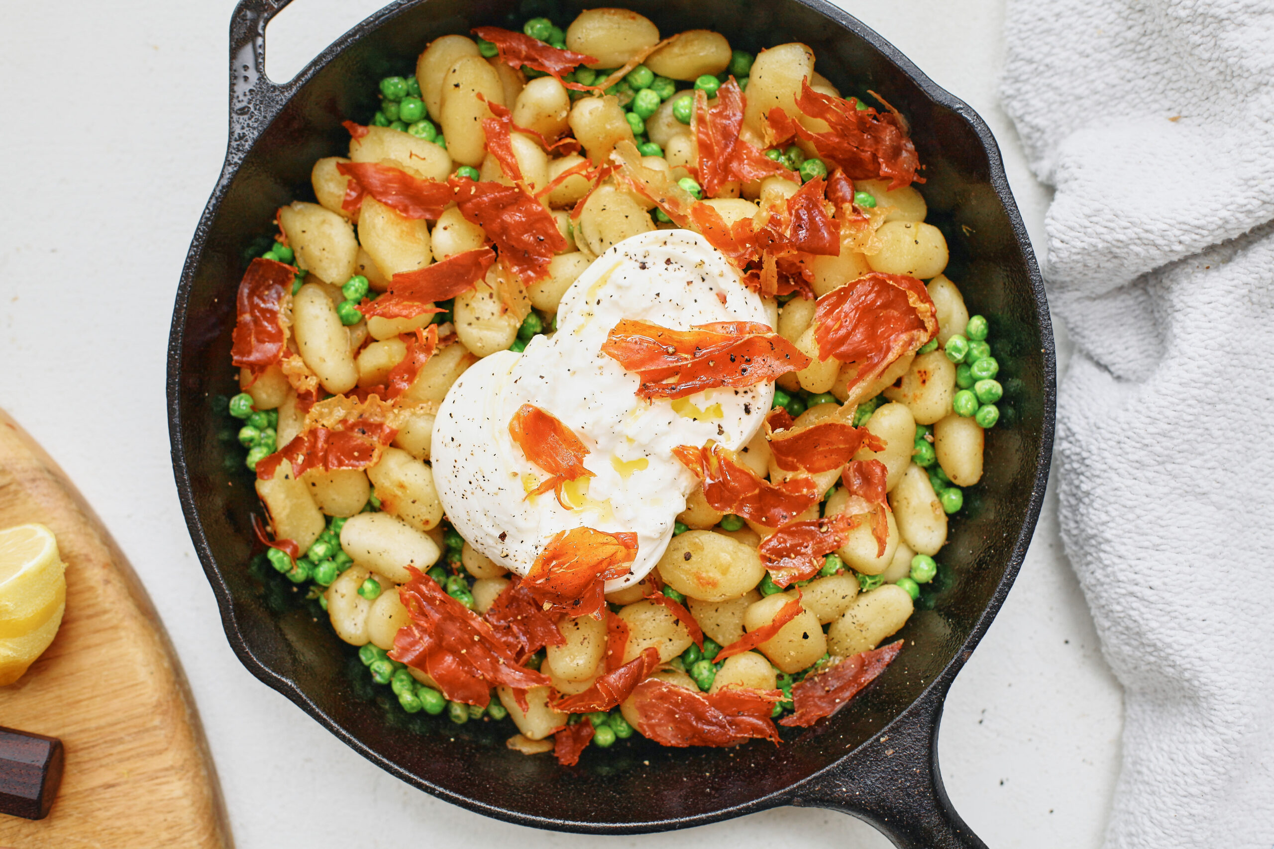 Crispy Gnocchi with Burrata, Peas & Prosciutto in a cast iron skillet