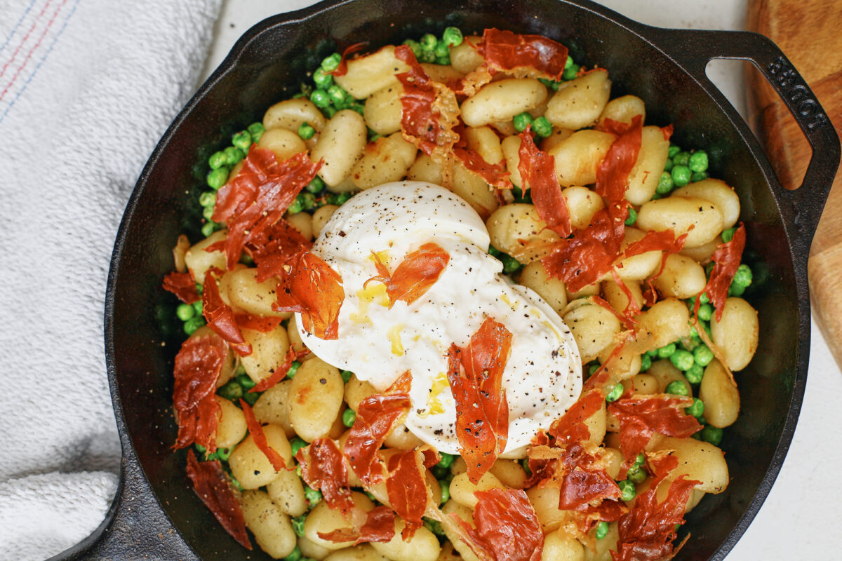 Crispy Gnocchi with Burrata, Peas & Prosciutto in a cast iron skillet