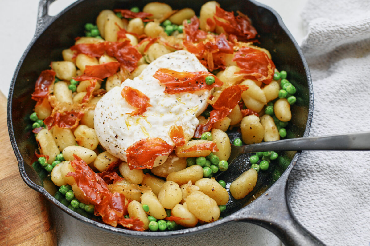 Crispy Gnocchi with Burrata, Peas & Prosciutto in a cast iron skillet