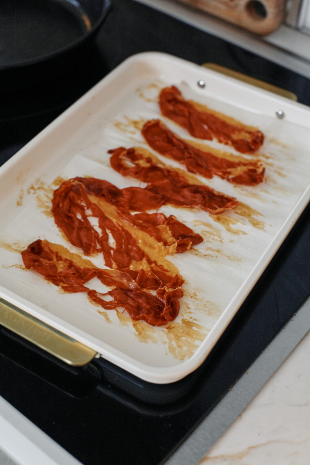 prosciutto on a parchment-lined making sheet after being crisped up in the oven