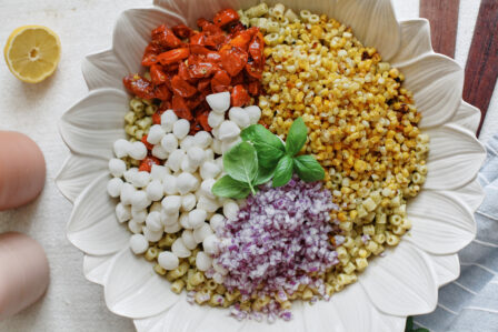 Ditalini pasta topped with roasted corn, tomatoes, mozzarella pearls, red onion and fresh basil