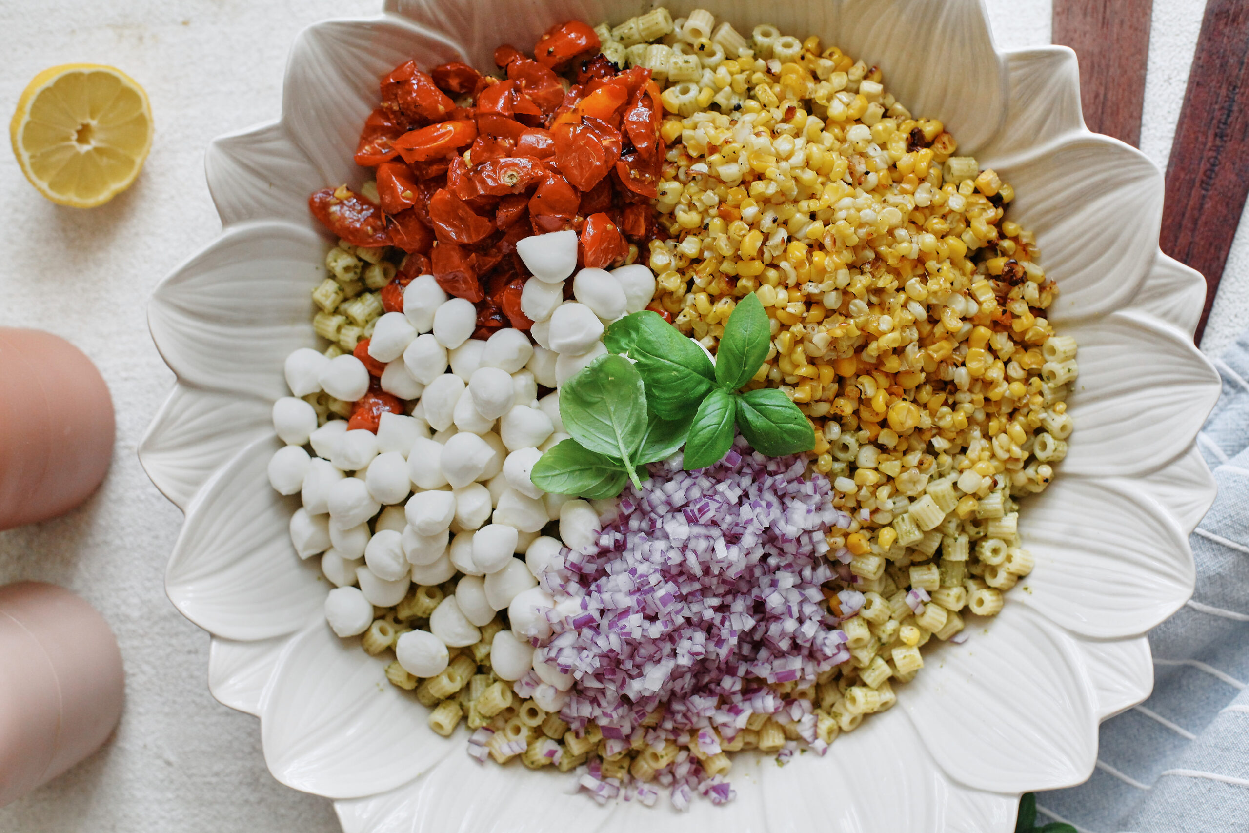Ditalini pasta topped with roasted corn, tomatoes, mozzarella pearls, red onion and fresh basil
