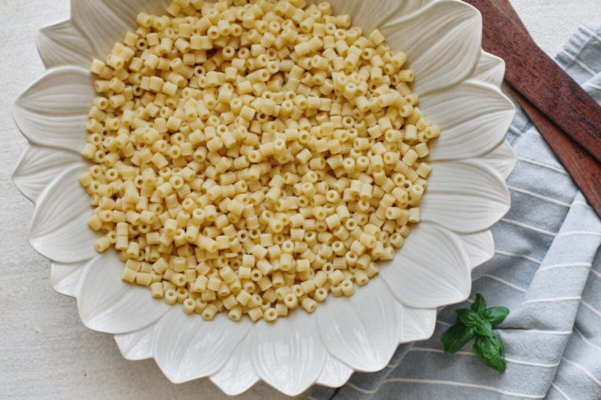 Cooked ditalini pasta in a large white flower-shaped serving bowl