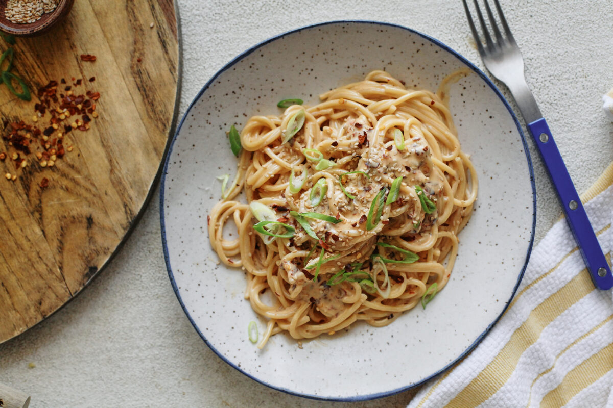 creamy chili oil spaghetti in a white speckled bowl
