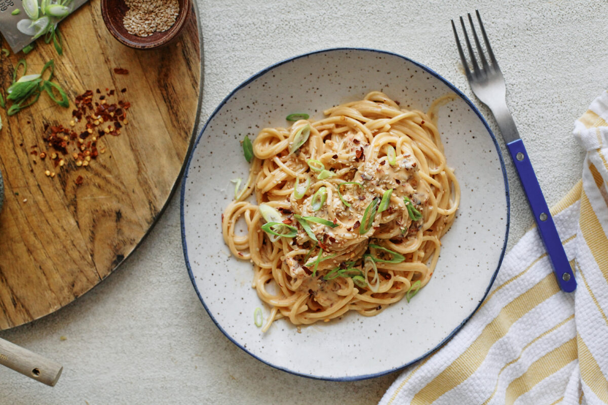 creamy chili oil spaghetti in a white speckled bowl