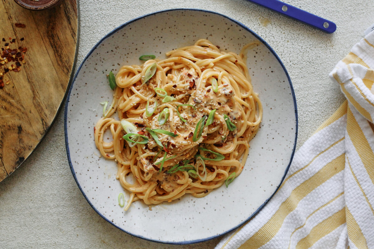 creamy chili oil spaghetti in a white speckled bowl