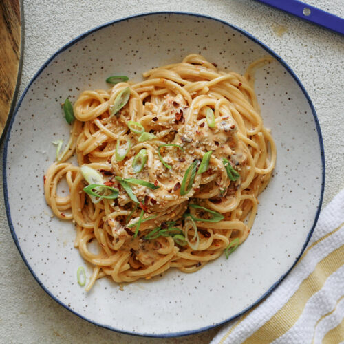 creamy chili oil spaghetti in a white speckled bowl
