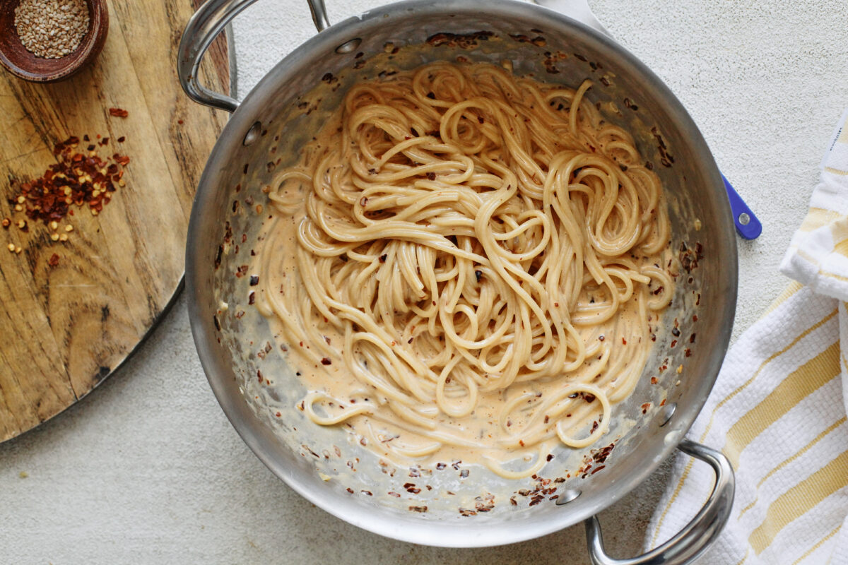 creamy chili oil spaghetti in a hammered steel saute pan