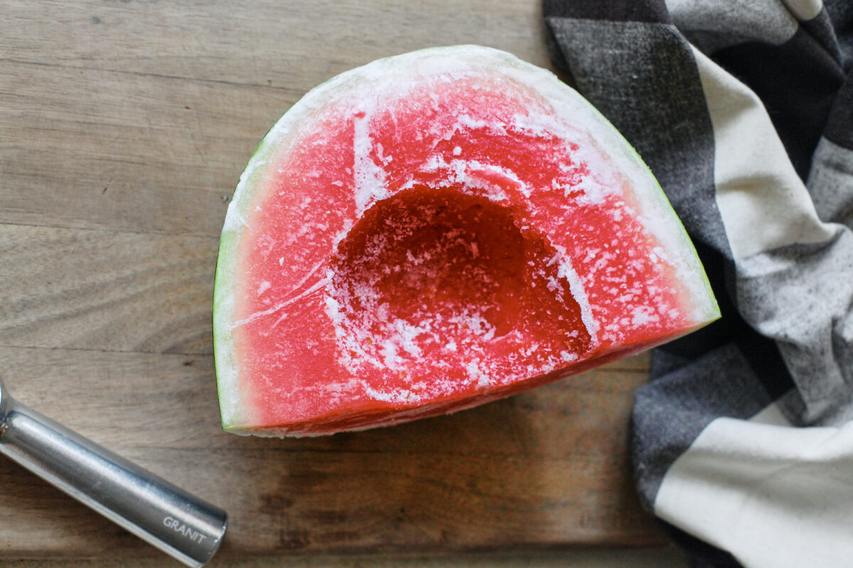 one quarter of frozen watermelon with some of the middle scooped out