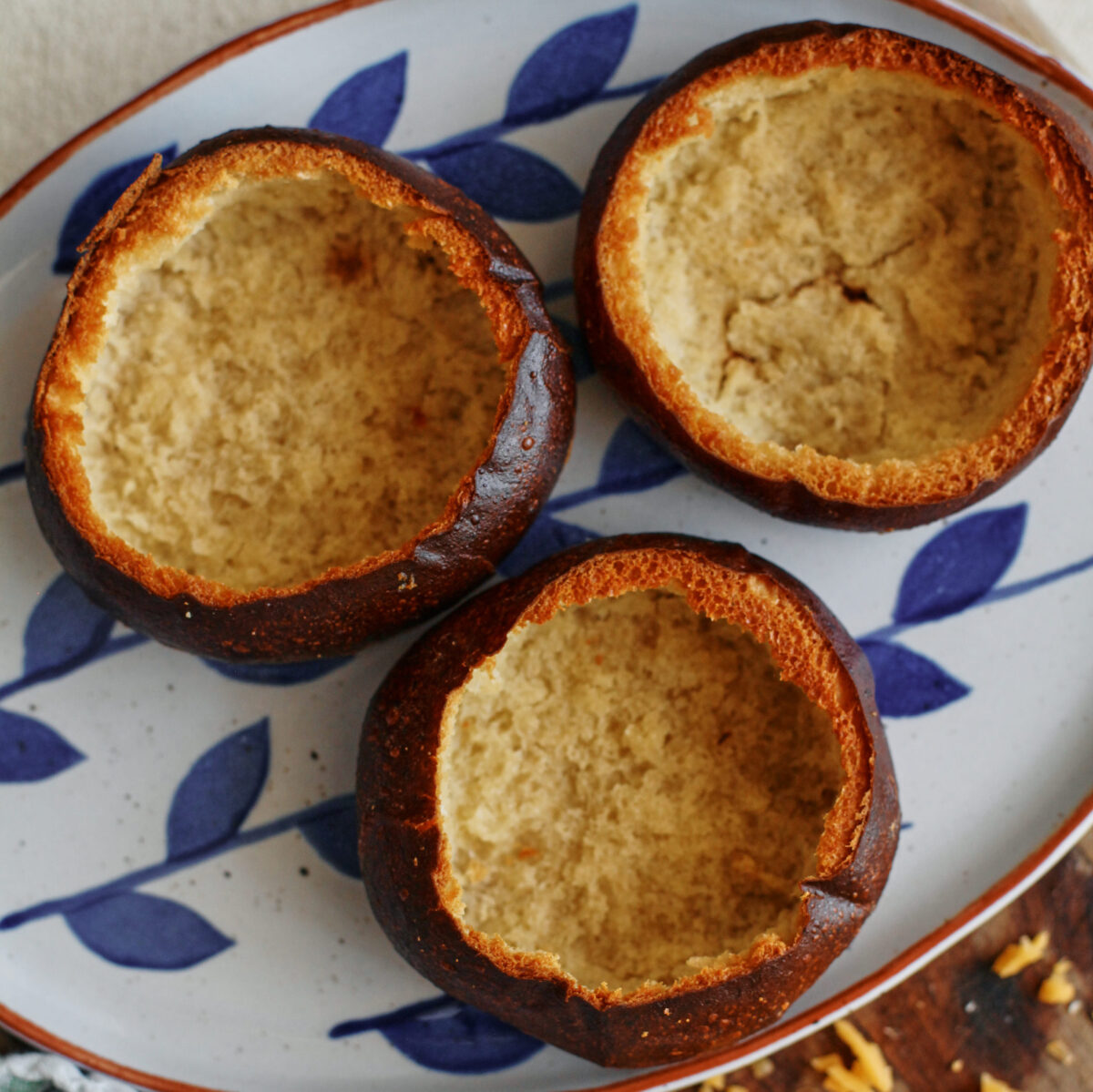 three pretzel buns with the middle scooped out to make a bowl, after being baked in the oven