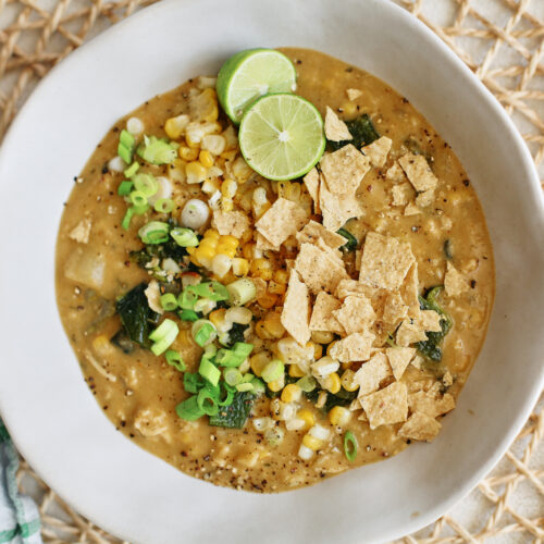 creamy poblano corn chowder topped with crushed tortilla chips, green onion, lime, and extra corn and chopped poblanos
