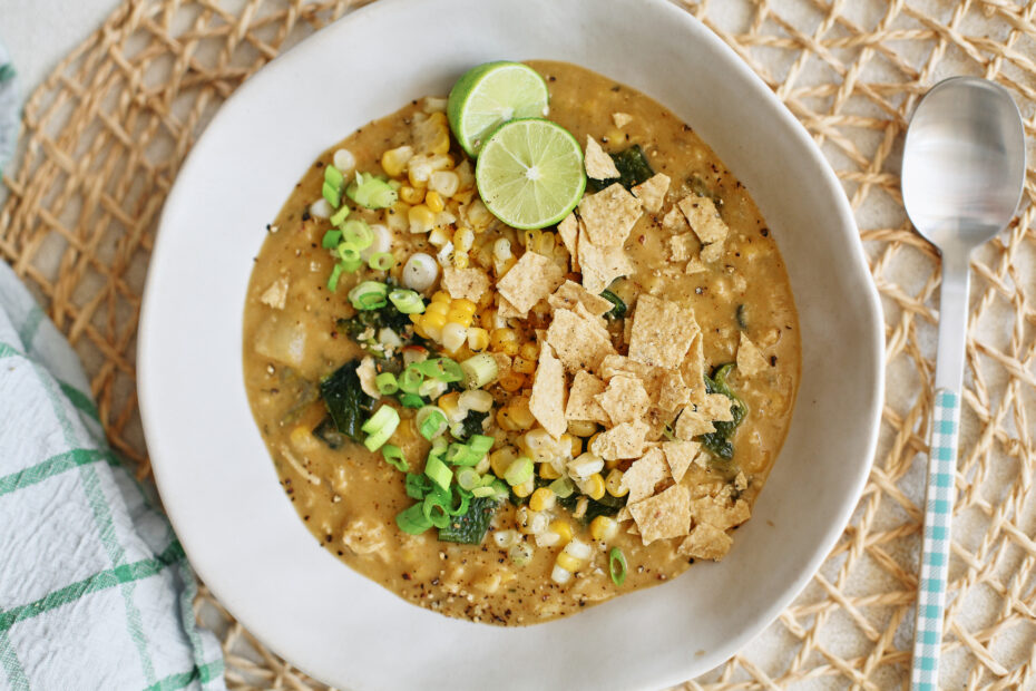 creamy poblano corn chowder topped with crushed tortilla chips, green onion, lime, and extra corn and chopped poblanos