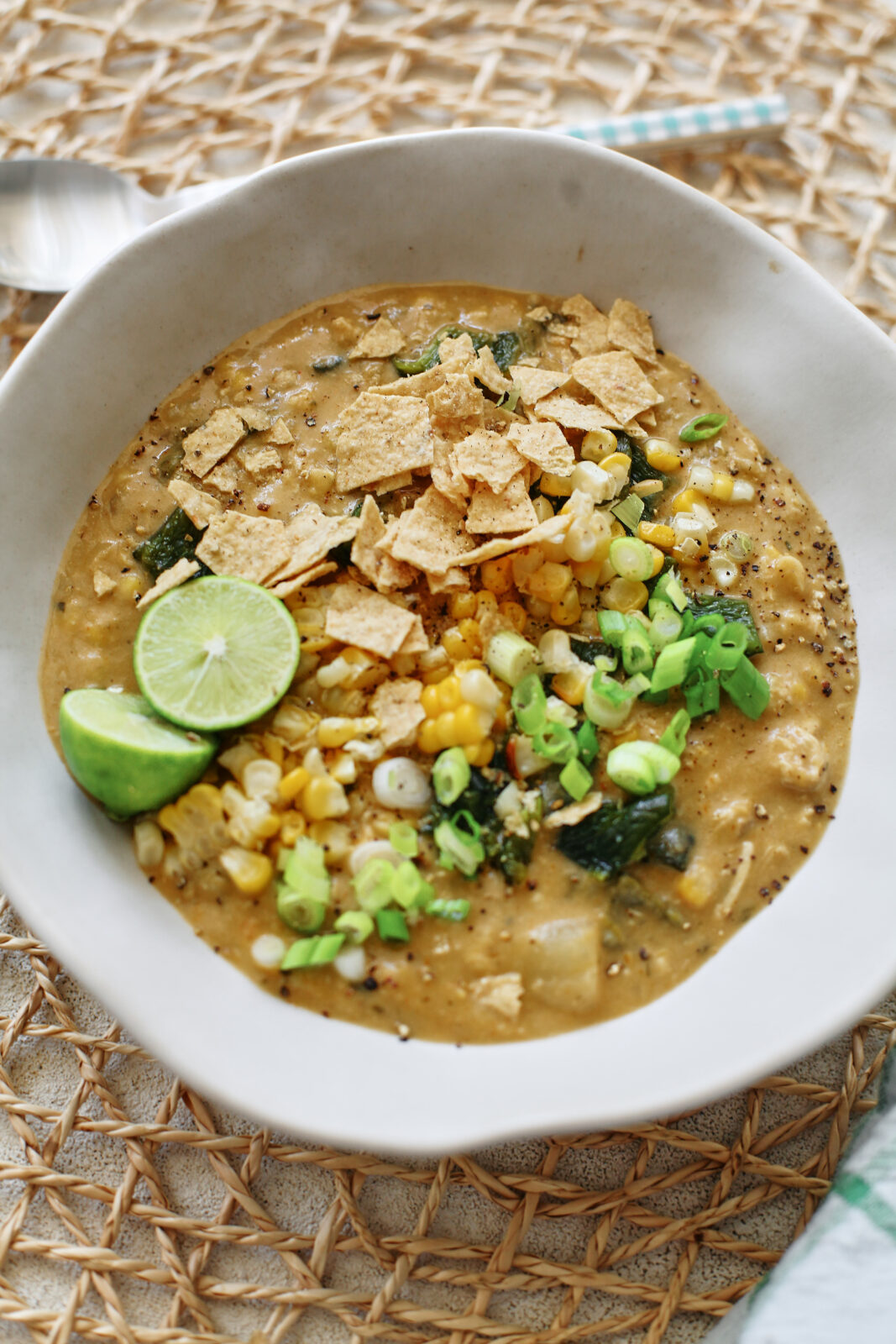 creamy poblano corn chowder topped with crushed tortilla chips, green onion, lime, and extra corn and chopped poblanos