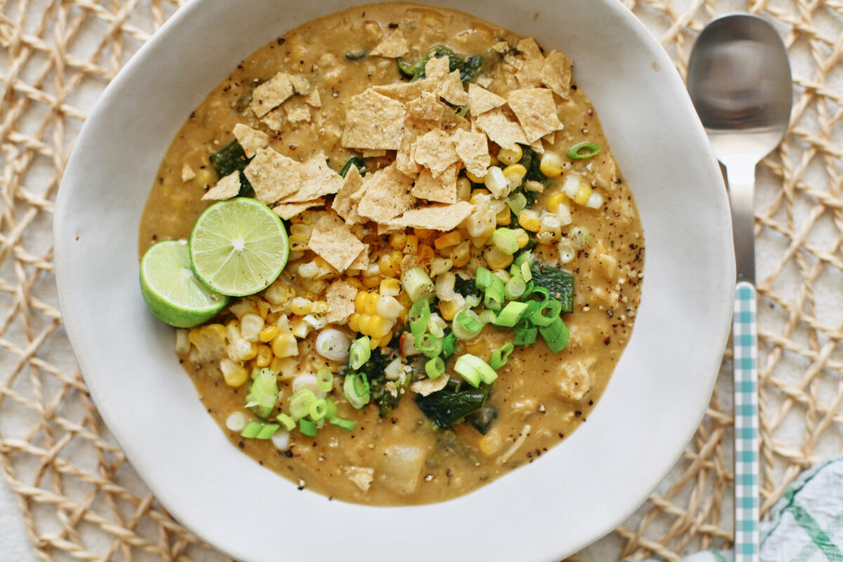 creamy poblano corn chowder topped with crushed tortilla chips, green onion, lime, and extra corn and chopped poblanos