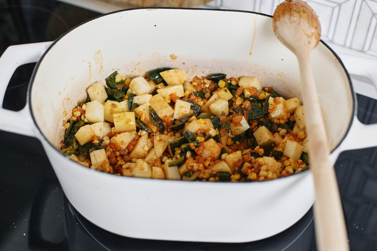 chopped potato, poblanos, and corn added to the dutch oven and sautéing with the onion and spices