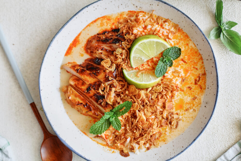 spicy yellow curry chicken & brothy rice bowl topped with crispy shallots, mint, and lime wedges