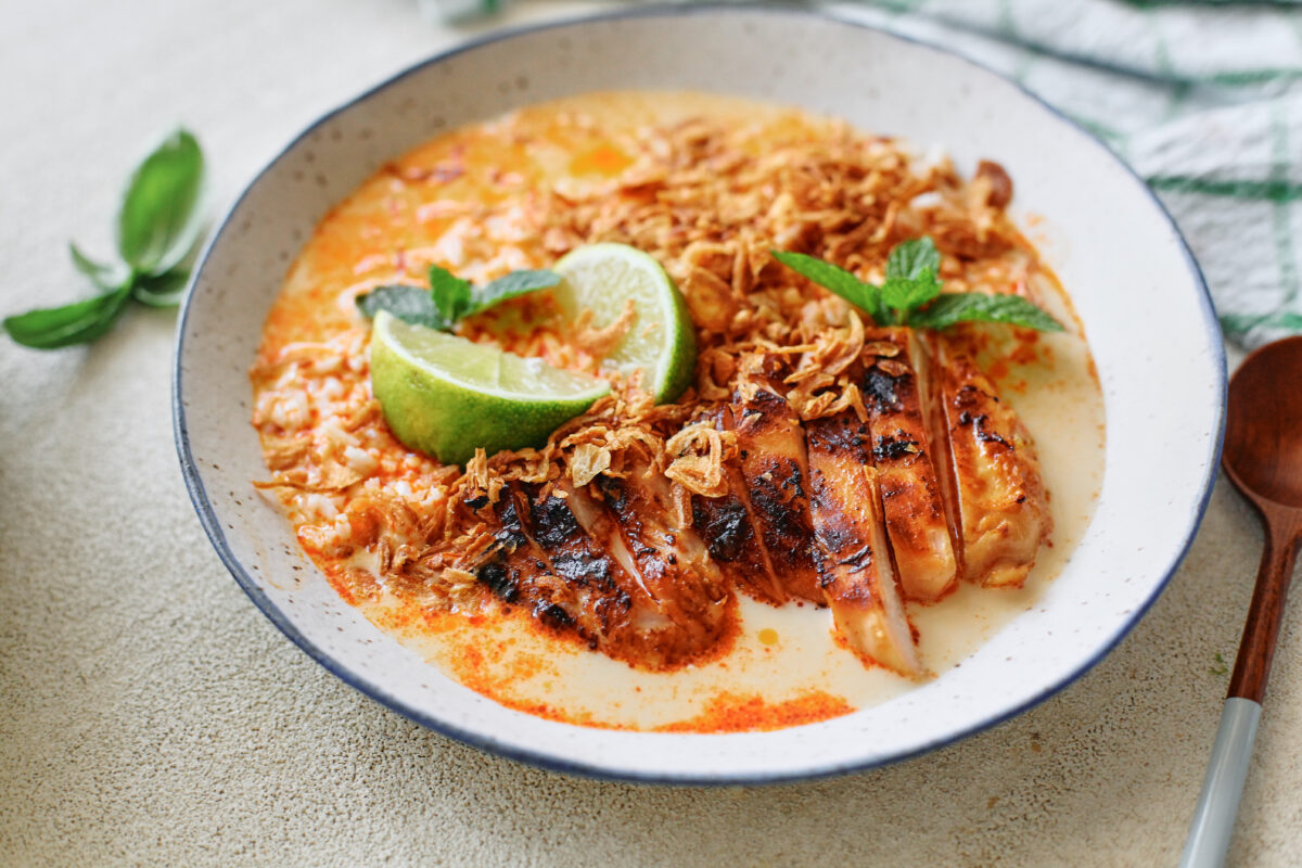 spicy yellow curry chicken & brothy rice bowl topped with crispy shallots, mint, and lime wedges